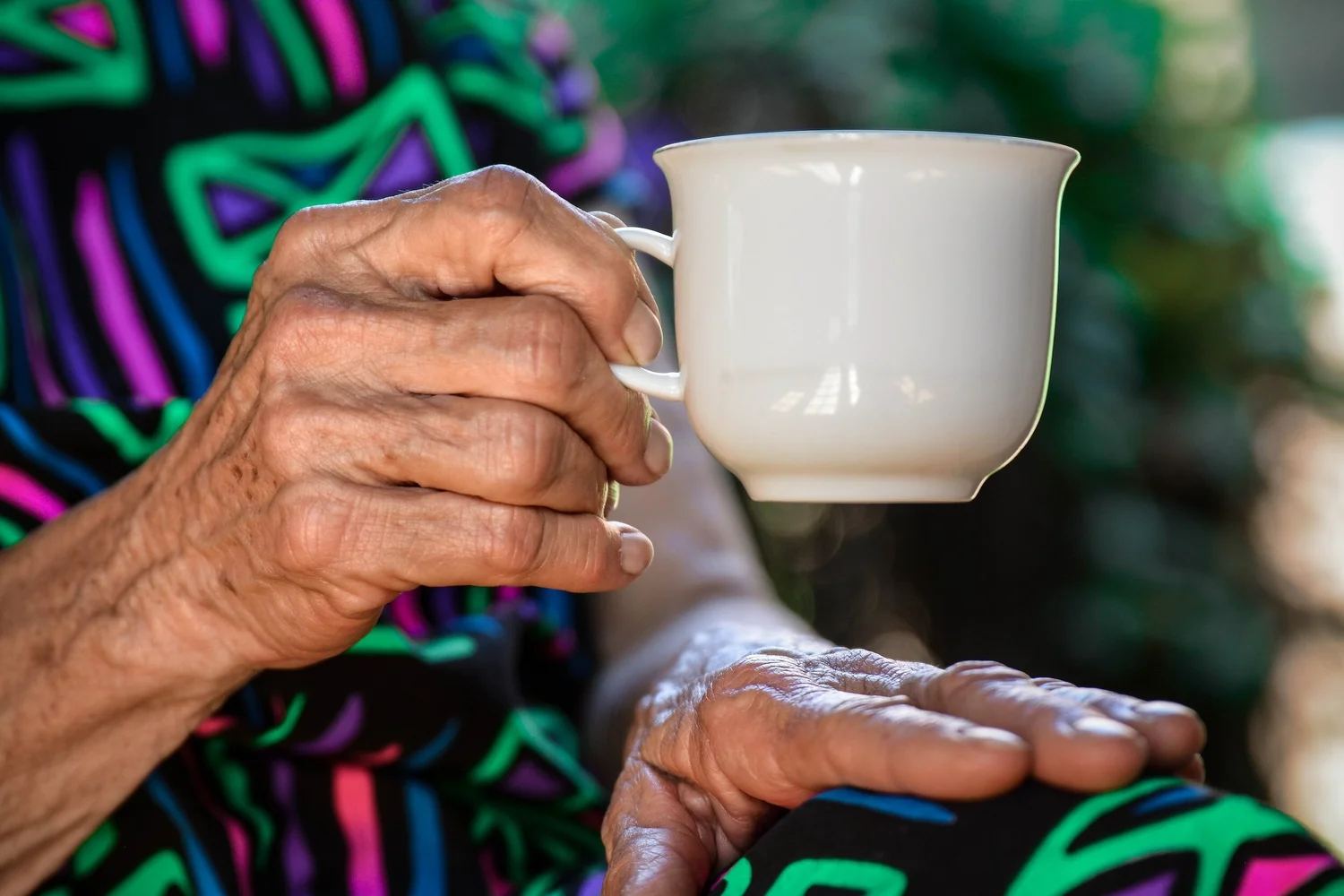Parkinson’s Disease patient with hands shaking, making it difficult to hold a mug