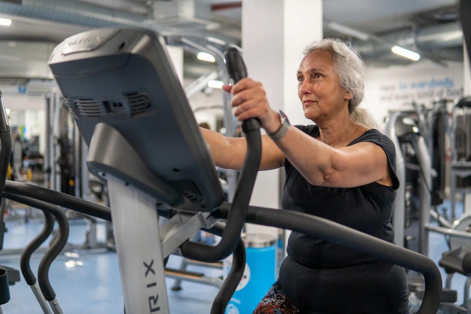 An older woman exercising on an elliptical machine