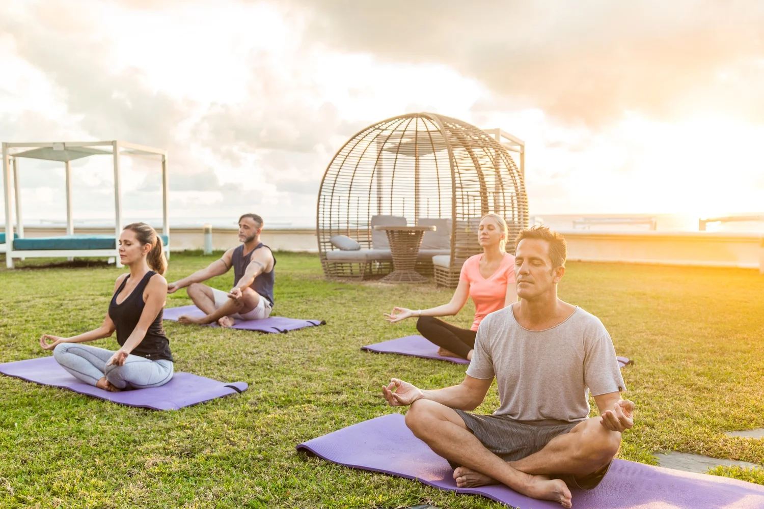 A group doing yoga outdoors at sunset